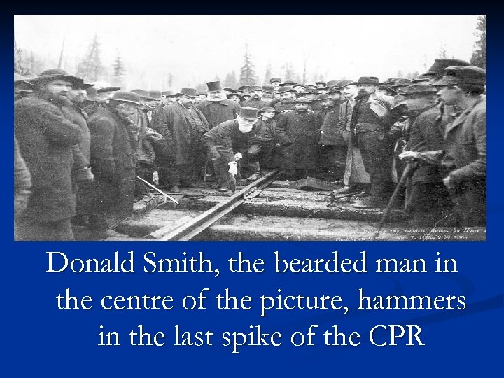 Donald Smith, the bearded man in the centre of the picture, hammers in the