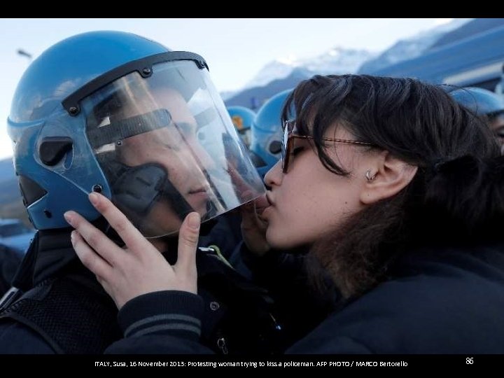 ITALY, Susa, 16 November 2013: Protesting woman trying to kiss a policeman. AFP PHOTO