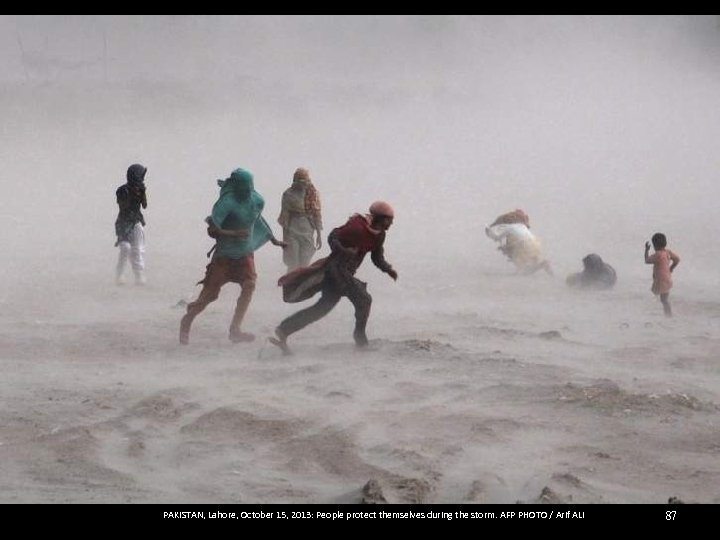 PAKISTAN, Lahore, October 15, 2013: People protect themselves during the storm. AFP PHOTO /