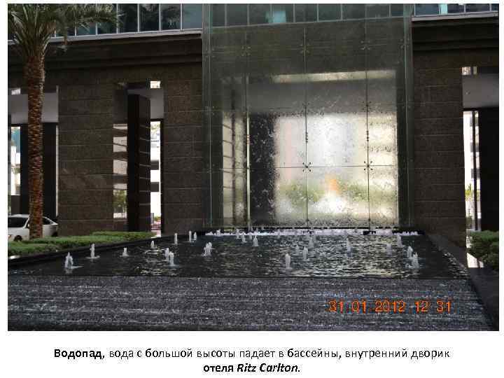 Водопад, вода с большой высоты падает в бассейны, внутренний дворик отеля Ritz Carlton. 