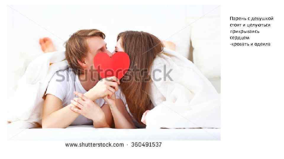 Парень с девушкой стоят и целуються прикрываясь сердцем -кровать и одеяла 
