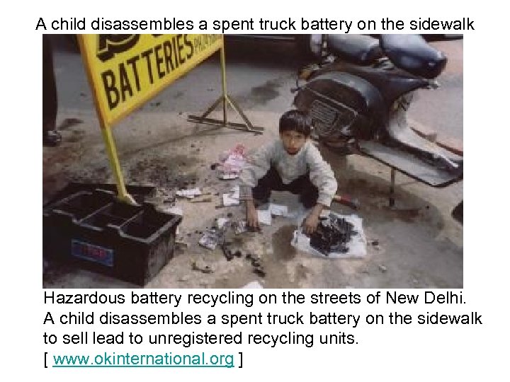 A child disassembles a spent truck battery on the sidewalk Hazardous battery recycling on