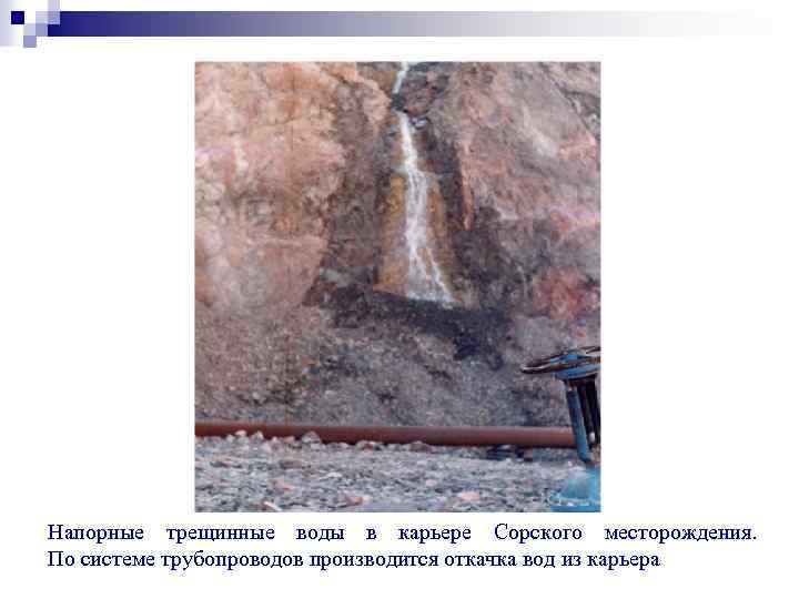 Напорные трещинные воды в карьере Сорского месторождения. По системе трубопроводов производится откачка вод из