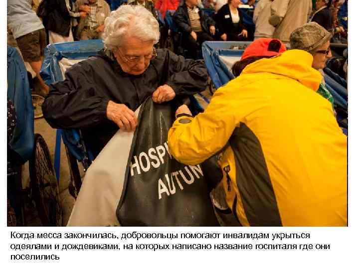 Когда месса закончилась, добровольцы помогают инвалидам укрыться одеялами и дождевиками, на которых написано название