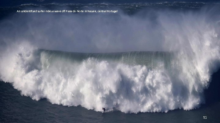 An unidentifyed surfer rides a wave off Praia do Norte in Nazare, central Portugal