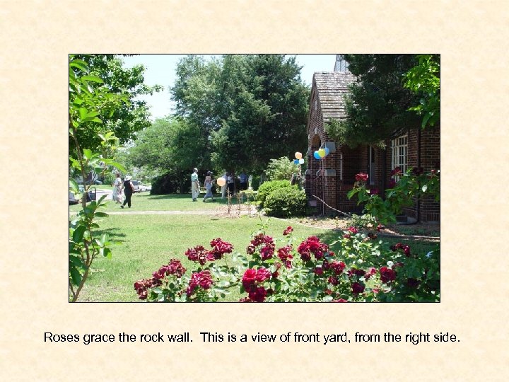 Roses grace the rock wall. This is a view of front yard, from the