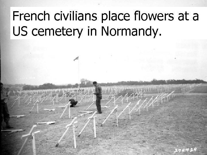 French civilians place flowers at a US cemetery in Normandy. 