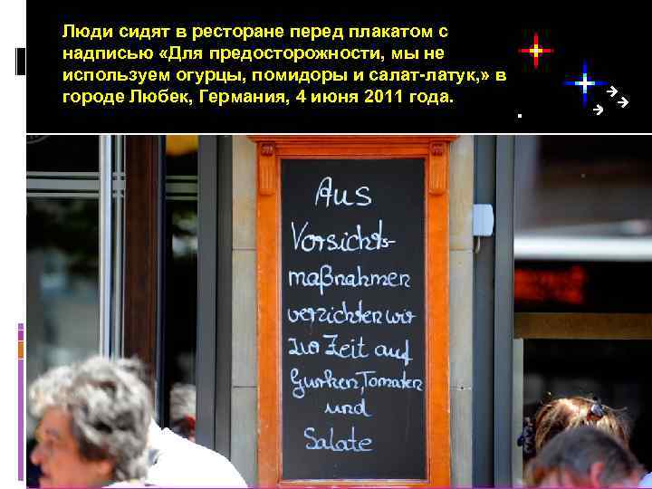 Люди сидят в ресторане перед плакатом с надписью «Для предосторожности, мы не используем огурцы,