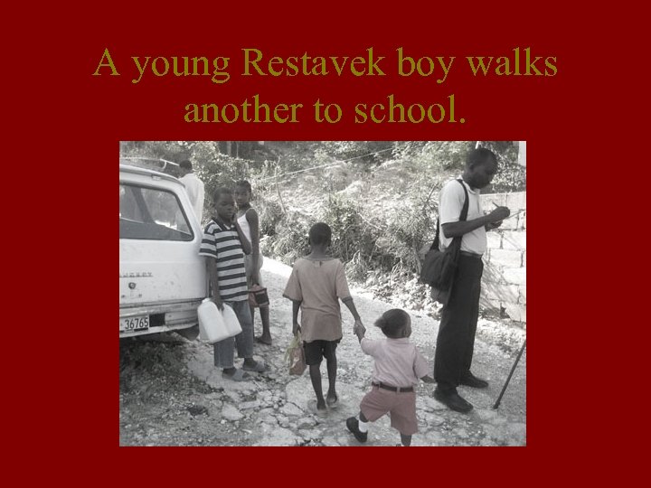 A young Restavek boy walks another to school. 