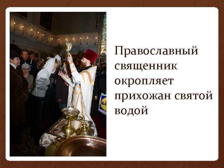 Православный священник окропляет прихожан святой водой 
