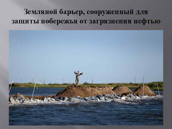 Земляной барьер, сооруженный для защиты побережья от загрязнения нефтью 