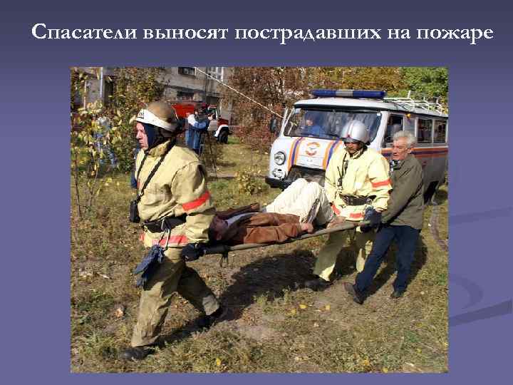 Спасатели выносят пострадавших на пожаре 