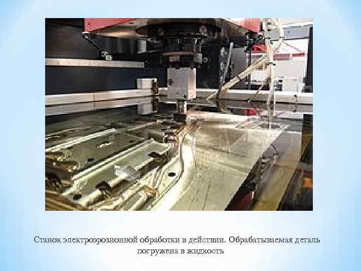 Станок электроэрозионной обработки в действии. Обрабатываемая деталь погружена в жидкость 