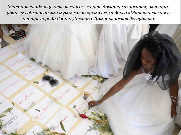 Женщина кладет цветы на список жертв домашнего насилия,  женщин,  убитых собственными мужьями