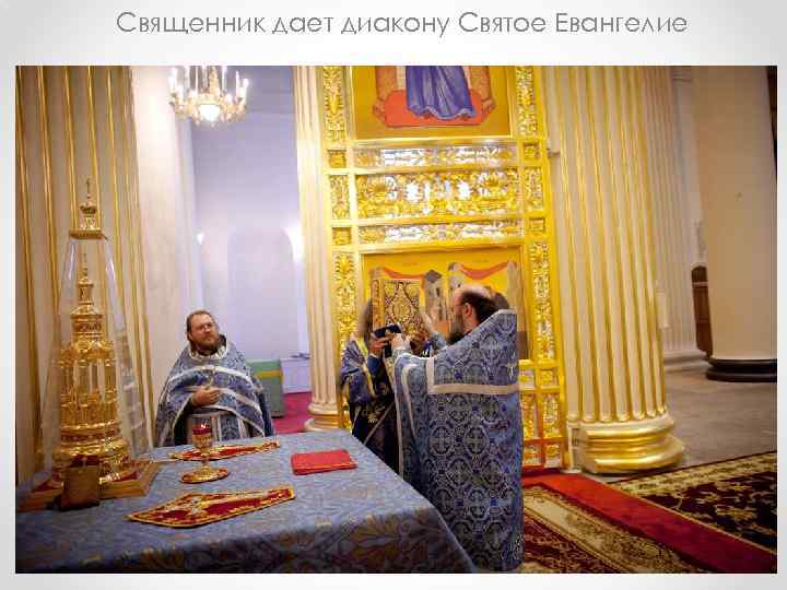 Священник дает диакону Святое Евангелие 