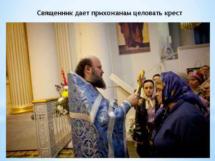 Священник дает прихожанам целовать крест 