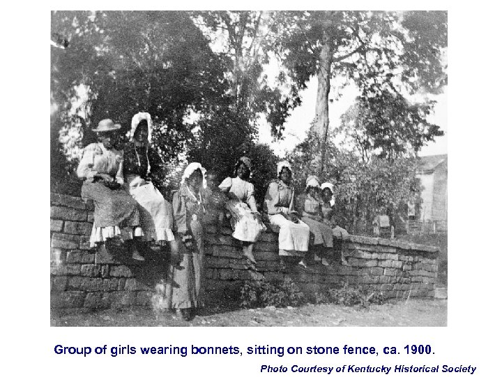 Group of girls wearing bonnets, sitting on stone fence, ca. 1900. Photo Courtesy of