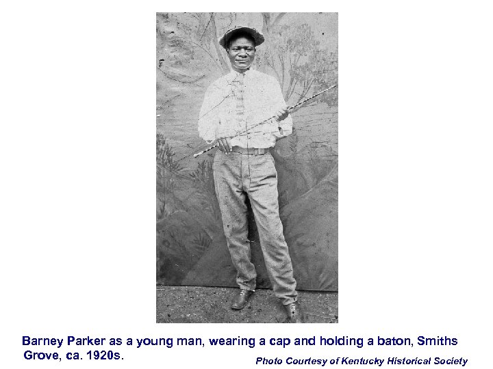 Barney Parker as a young man, wearing a cap and holding a baton, Smiths