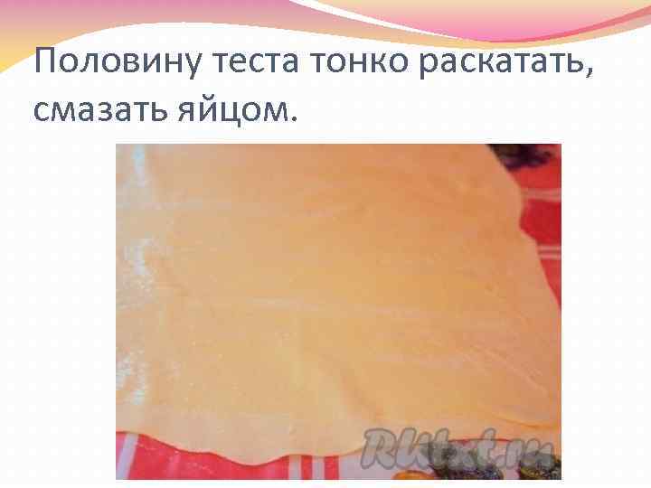 Половину теста тонко раскатать, смазать яйцом. 