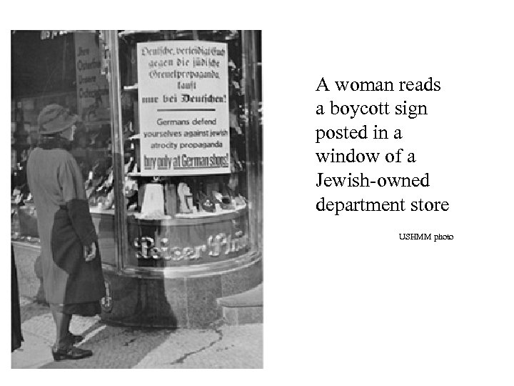 A woman reads a boycott sign posted in a window of a Jewish-owned department