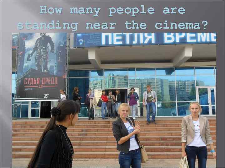 How many people are standing near the cinema? 