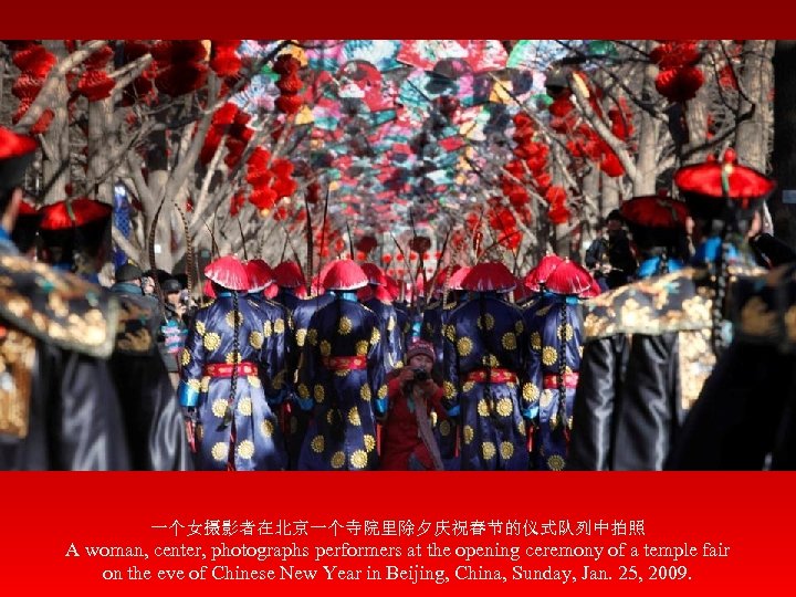 一个女摄影者在北京一个寺院里除夕庆祝春节的仪式队列中拍照 A woman, center, photographs performers at the opening ceremony of a temple fair