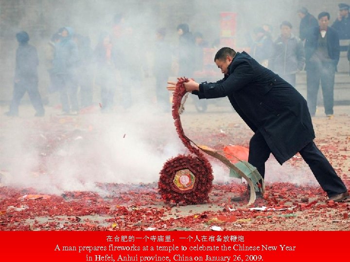 在合肥的一个寺庙里，一个人在准备放鞭炮 A man prepares fireworks at a temple to celebrate the Chinese New Year