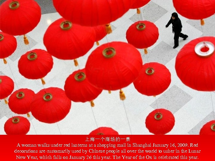 上海一个商场的一景 A woman walks under red lanterns at a shopping mall in Shanghai January