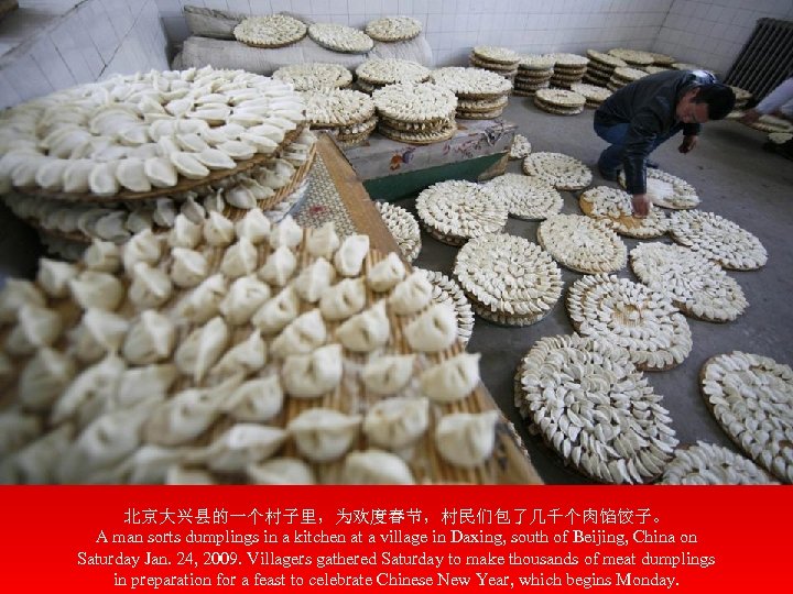北京大兴县的一个村子里，为欢度春节，村民们包了几千个肉馅饺子。 A man sorts dumplings in a kitchen at a village in Daxing, south