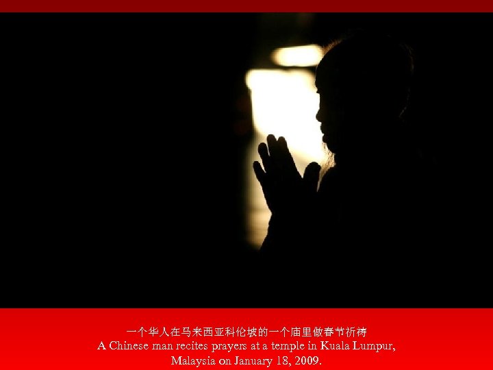 一个华人在马来西亚科伦坡的一个庙里做春节祈祷 A Chinese man recites prayers at a temple in Kuala Lumpur, Malaysia on