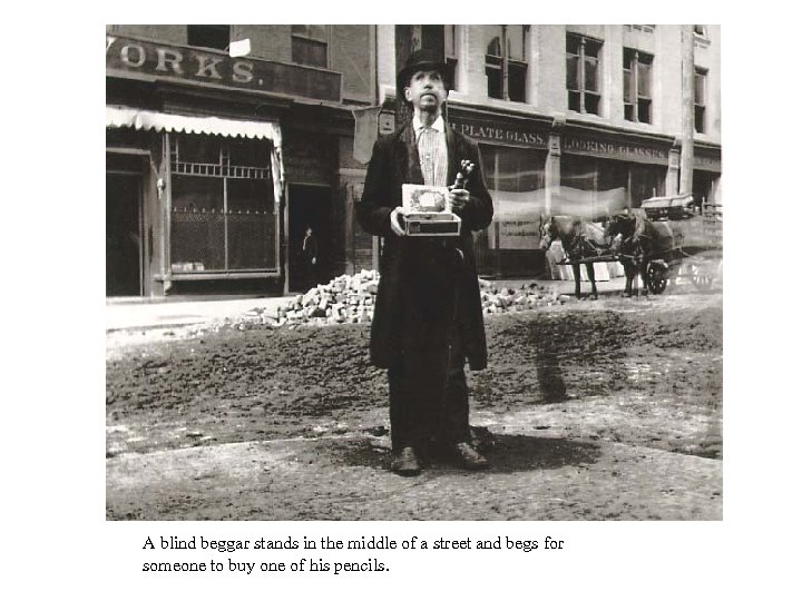 A blind beggar stands in the middle of a street and begs for someone