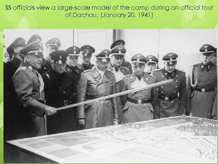 SS officials view a large-scale model of the camp during an official tour of