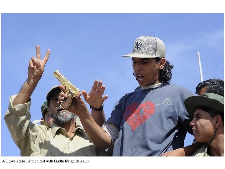 A Libyan rebel is pictured with Gadhafi's golden gun. 