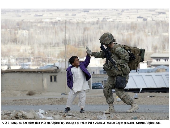 A U. S. Army soldier takes five with an Afghan boy during a patrol
