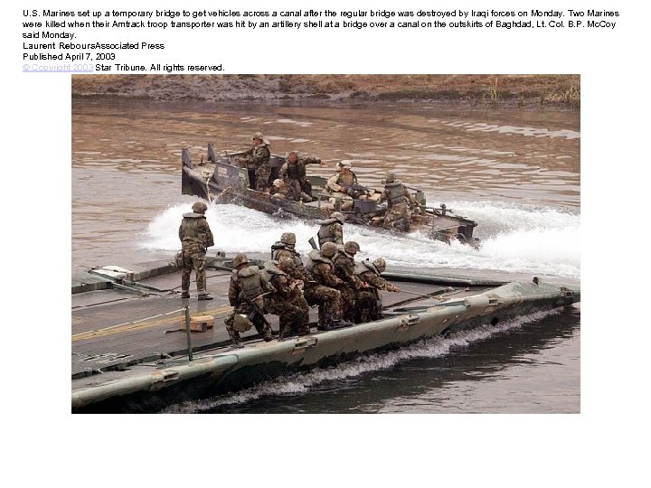 U. S. Marines set up a temporary bridge to get vehicles across a canal