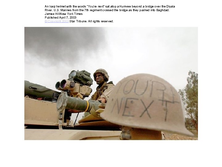 An Iraqi helmet with the words "You're next" sat atop a Humvee beyond a
