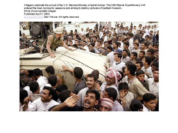 Villagers celebrate the arrival of the U. S. Marines Monday in Qal'at Sukkar. The