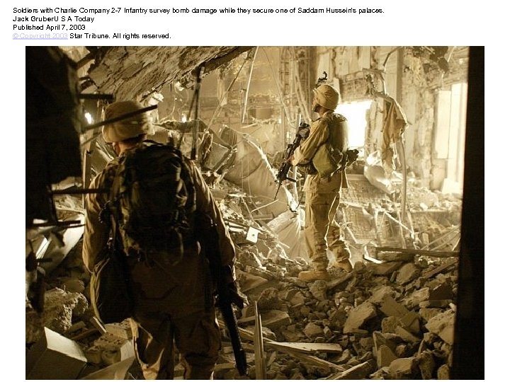 Soldiers with Charlie Company 2 -7 Infantry survey bomb damage while they secure one