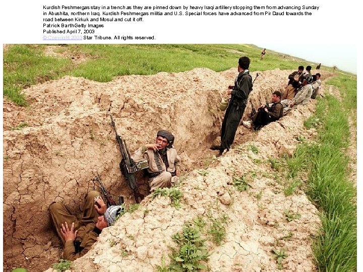 Kurdish Peshmergas stay in a trench as they are pinned down by heavy Iraqi