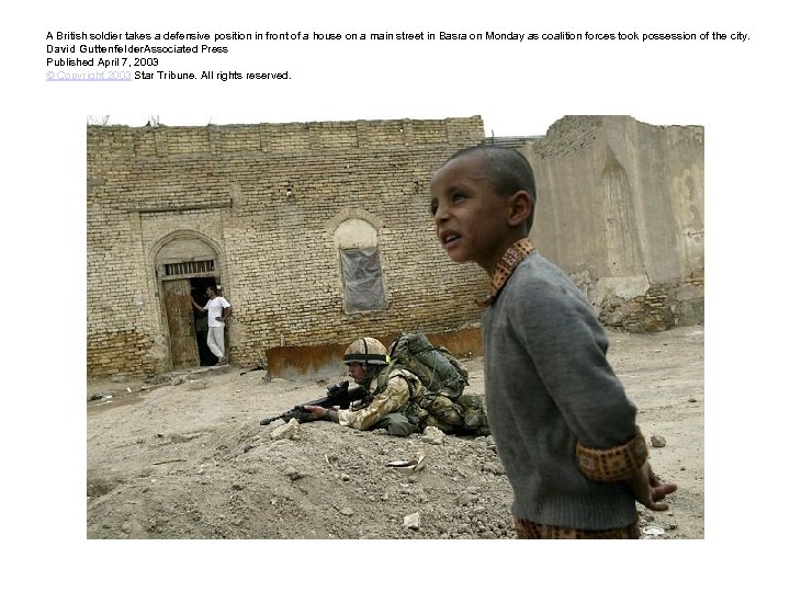 A British soldier takes a defensive position in front of a house on a