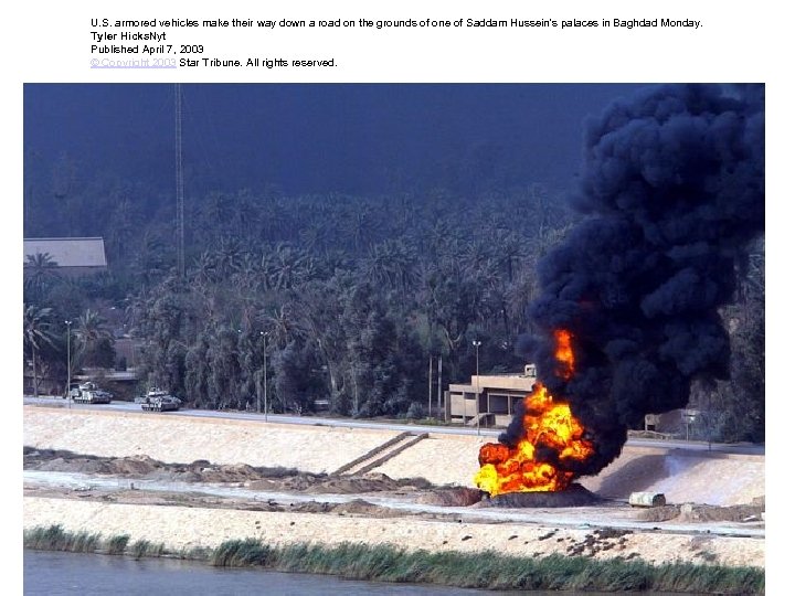 U. S. armored vehicles make their way down a road on the grounds of