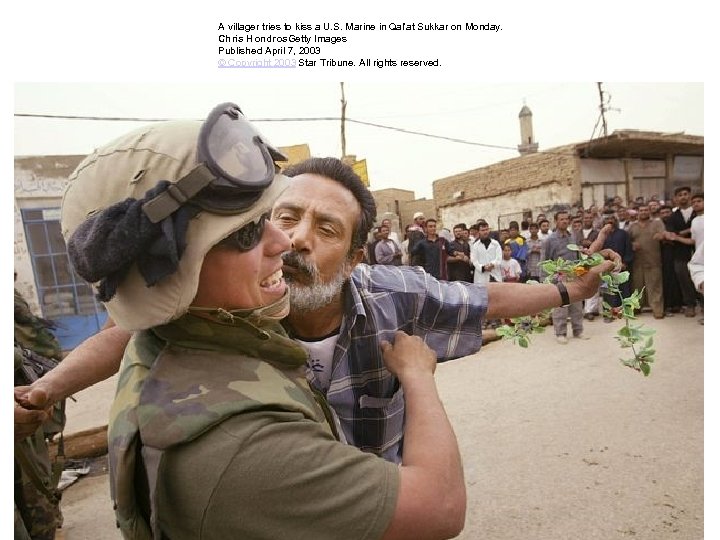 A villager tries to kiss a U. S. Marine in Qal'at Sukkar on Monday.