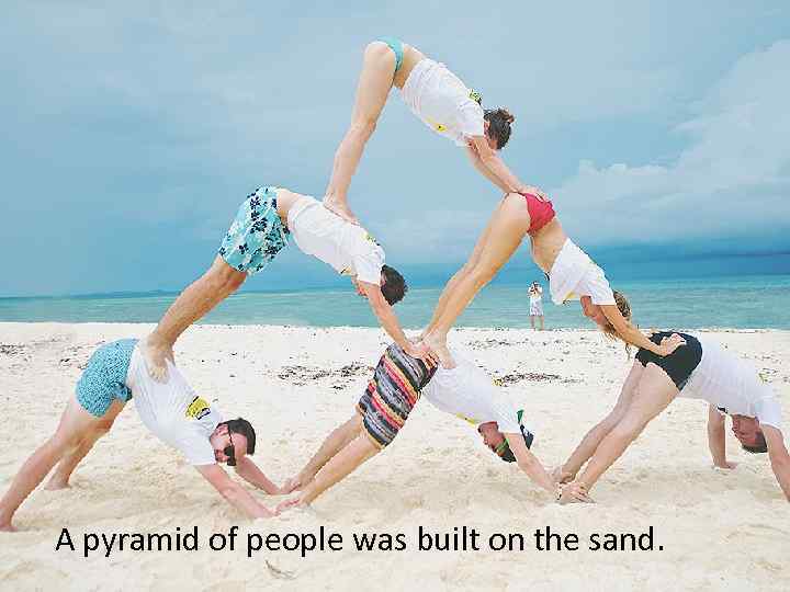 A pyramid of people was built on the sand. 