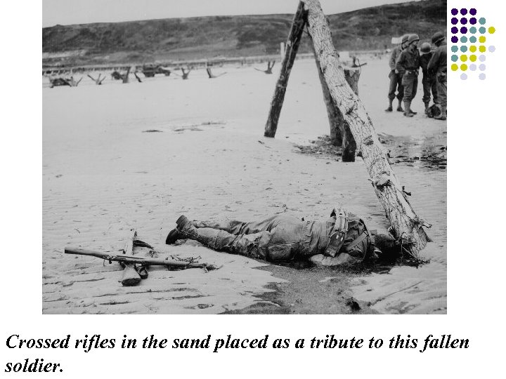 Crossed rifles in the sand placed as a tribute to this fallen soldier. 