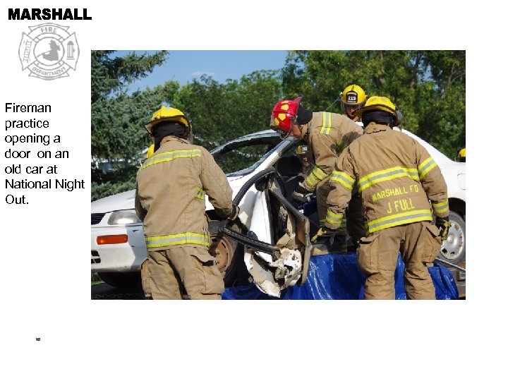 Fireman practice opening a door on an old car at National Night Out. 