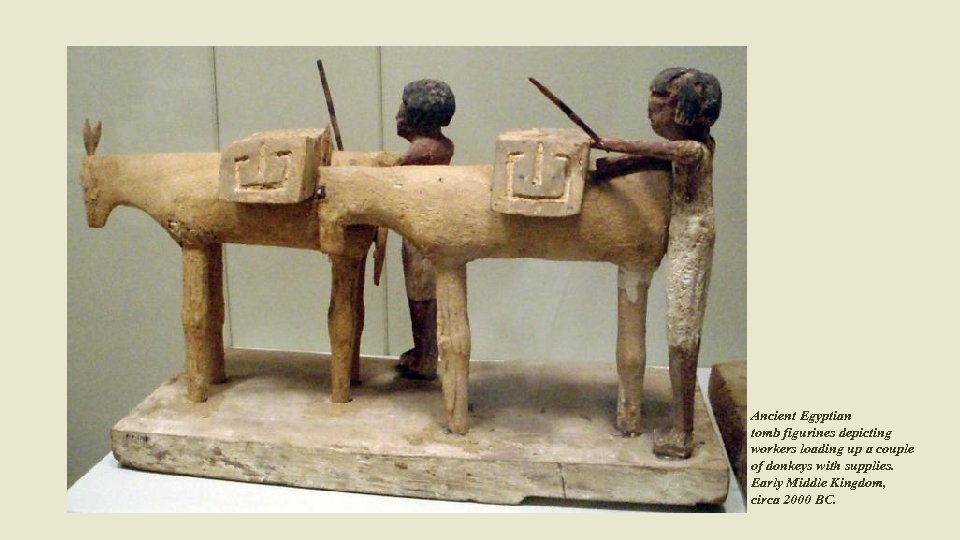 Ancient Egyptian tomb figurines depicting workers loading up a couple of donkeys with supplies.
