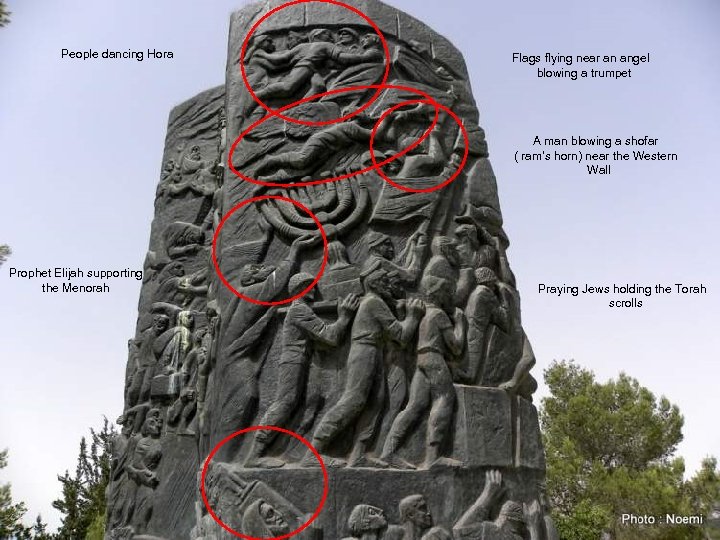 People dancing Hora Flags flying near an angel blowing a trumpet A man blowing