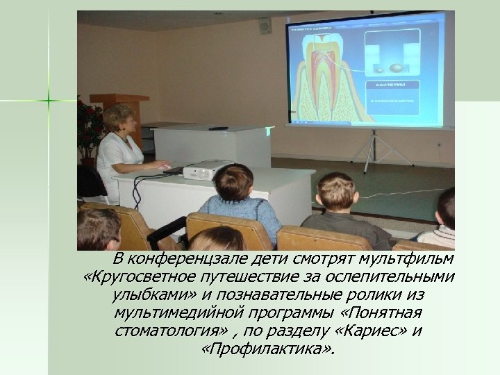 В конференцзале дети смотрят мультфильм «Кругосветное путешествие за ослепительными улыбками» и познавательные ролики из