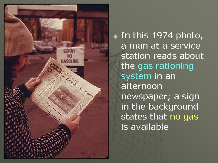 u In this 1974 photo, a man at a service station reads about the