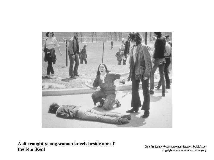 A distraught young woman kneels beside one of the four Kent Give Me Liberty!: